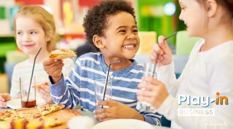 des enfants en train de manger un goûter autour d'une table.